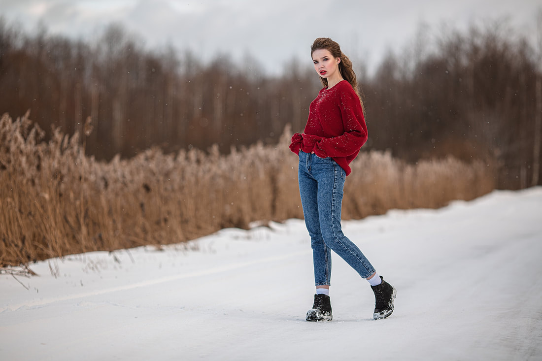 Trendy model standing on a snowy roadway.