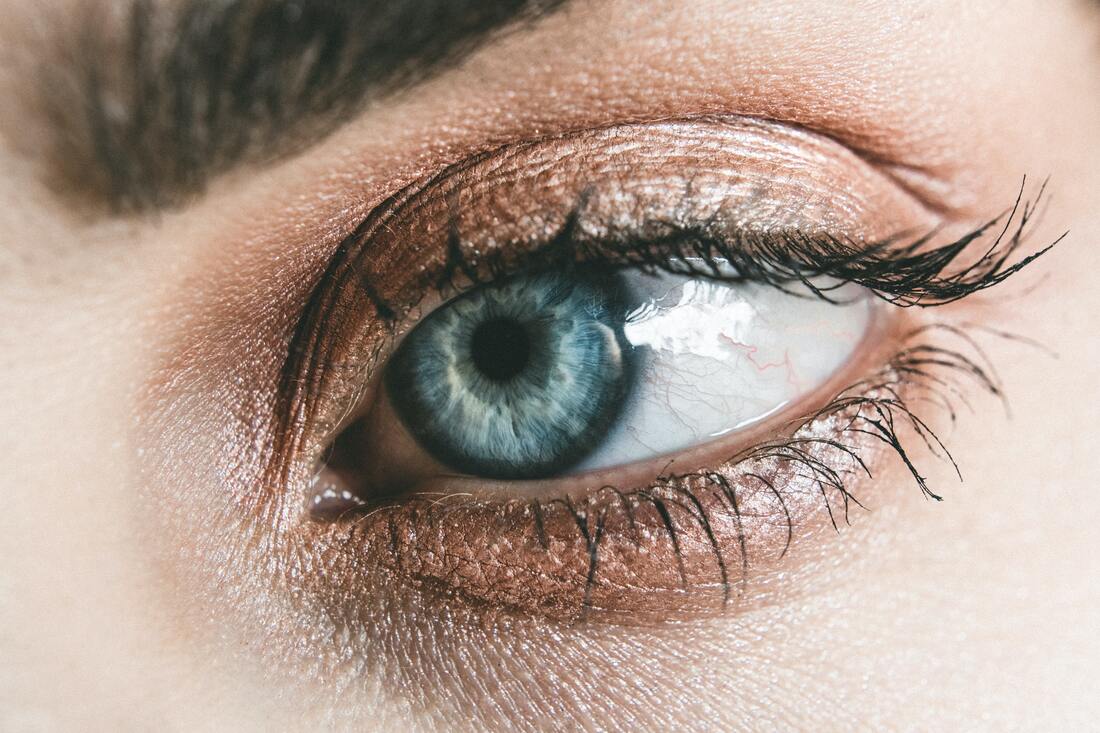 Closeup shot of a woman’s blue eye who is wearing neutral eyeshadow.