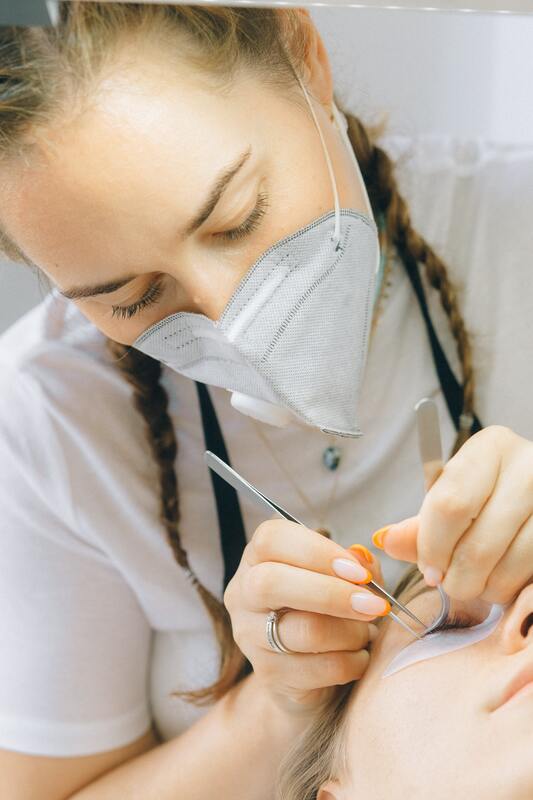 Lash technician performing an eyelash treatment on a client