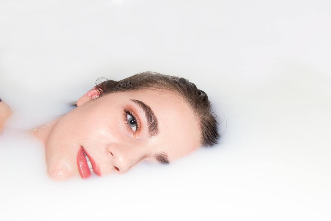 A girl lying in a bathtub for Brazilian waxing